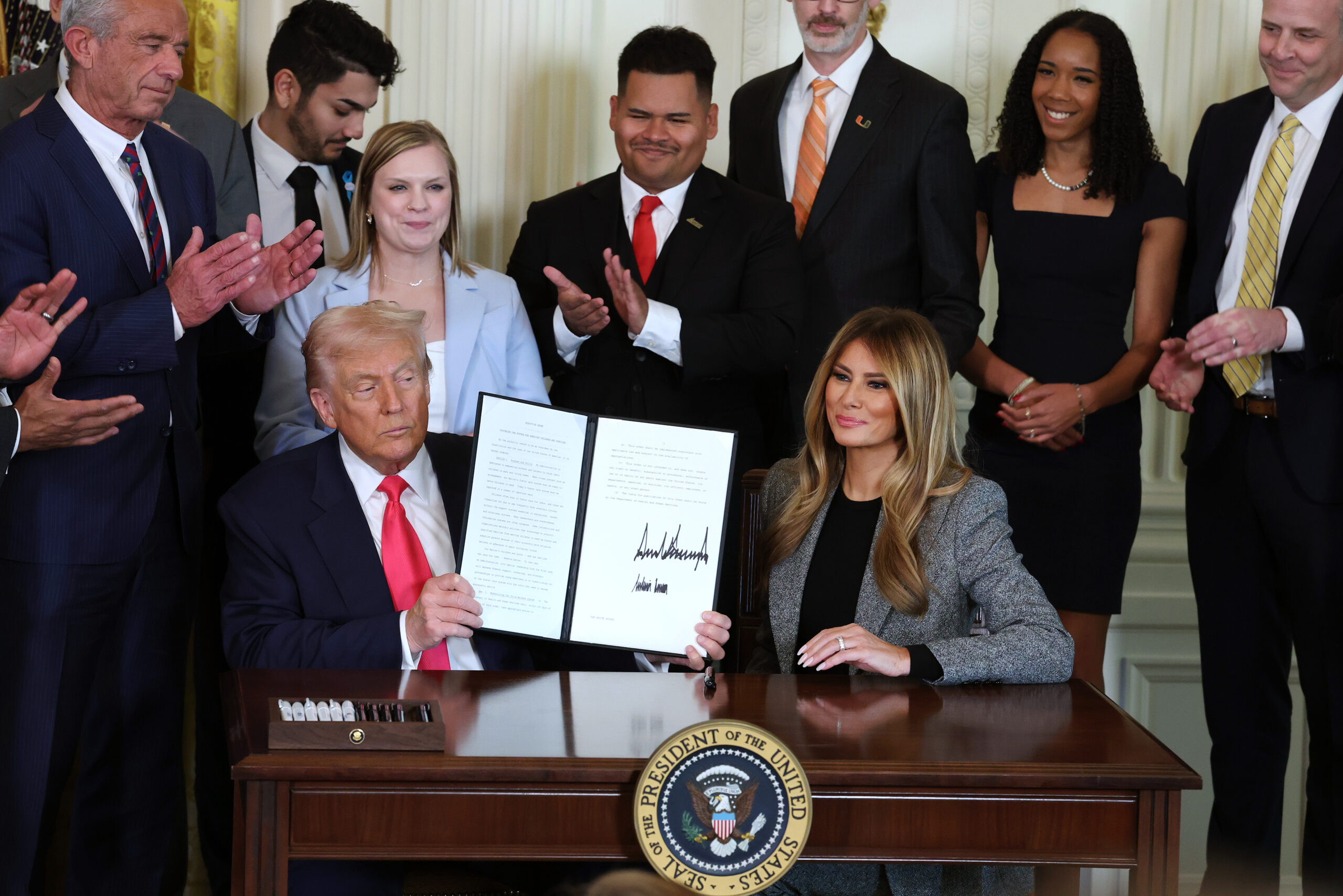 Melania Trump signs executive order with husband to help foster care children
